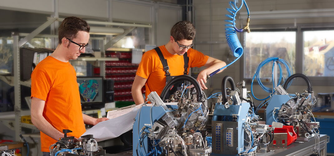 Two engineers manufacture precise devices for production processes